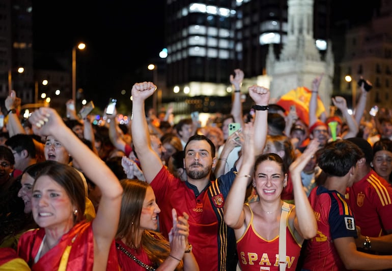 Los aficionados españoles celebran la victoria tras la final del Mundial 2026 entre España y Argentina mostrada en pantallas gigantes en la fan zone de la Plaza Colón de Madrid.