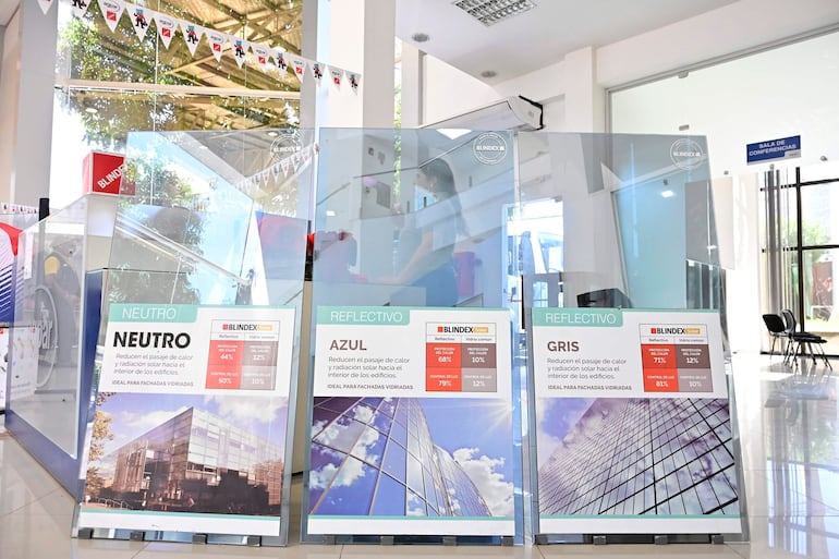 Paneles informativos de vidrio en sala moderna, con diseño gráfico y especificaciones sobre protección solar.