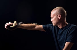 Esta fotografía sin fecha, proporcionada por Centivax y obtenida el 30 de mayo de 2025, muestra a Tim Friede, estadounidense de 57 años, quien se ha expuesto al veneno de serpiente cientos de veces con el objetivo de desarrollar inmunidad, posando con una cobra de agua.