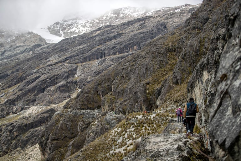 Turistas ascienden por la montaña y entre los acueductos en el monte Chacaltaya el 1 de marzo de 2026 en El Alto (Bolivia).