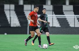 Goleadores en acción: Lorenzo Melgarejo, de Libertad, domina el esférico ante la vigilancia del experimentado César Villagra. (Foto: @Libertad_Guma)