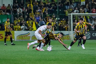 El delanter de General Caballero de Juan León Mallorquín, Clementino González intenta avanzar con el balón ante la marca del zaguero de Guaraní, Sebastián Zaracho.