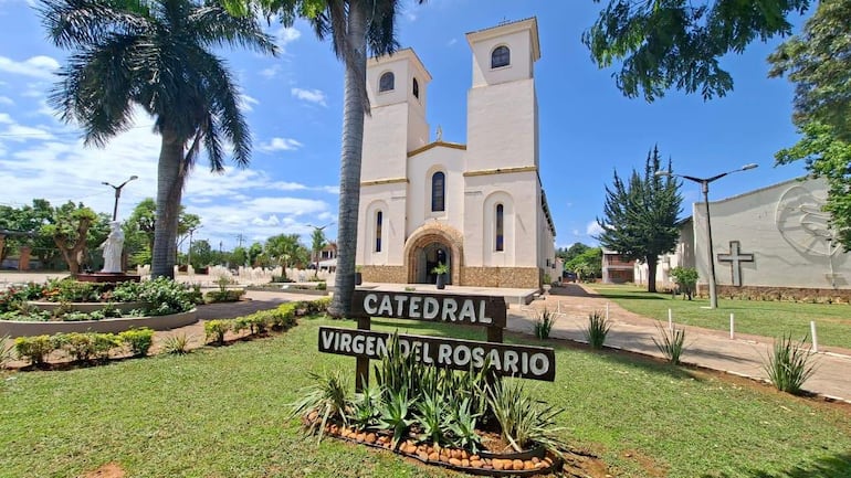 Catedral Virgen del Rosario con fachada blanca y torres, rodeada de jardines y un cielo despejado.