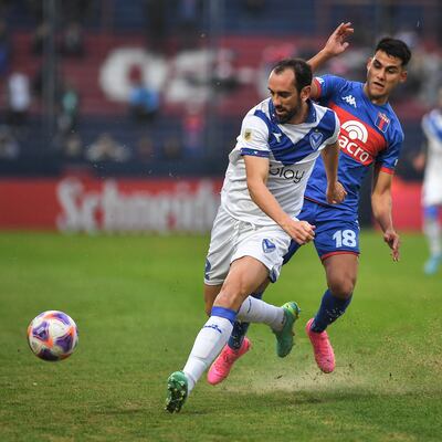 El delantero paraguayo Blas Armoa (d), de Tigre, disputa el balón con el zaguero uruguayo Diego Godín, de Vélez, durante el partido de ayer.