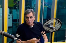 Víctor Pecci sentado en un estudio de radio, vistiendo camiseta negra con la palabra 'REBEL', hablando con gestos expresivos.
