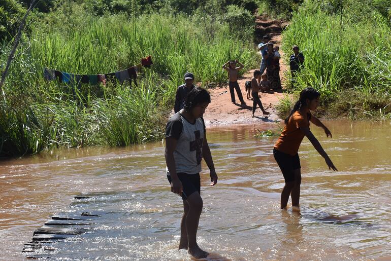 Los pobladores se arriesgan  a cruzar a pie el cauce del arroyo Tava´i, donde la comunidad solicita la construcción de un puente