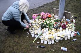 Una mujer enciende una vela en un monumento improvisado tras un tiroteo en la escuela Risbergska en Orebro, Suecia, el 05 de febrero de 2025. Según la policía, al menos 10 personas murieron y varias más resultaron heridas después de un tiroteo en la escuela Risbergska el 04 de febrero.