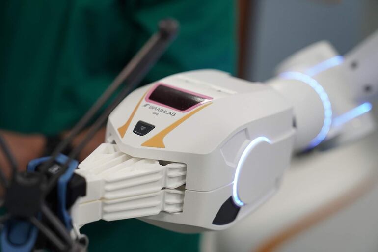 Dispositivo médico avanzado con diseño moderno, acabado blanco y luces LED en un ambiente clínico.