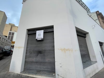 Edificio sin personas, con fachada blanca y ventana cerrada, cartel 'CENTURY 21' visible a un lado.