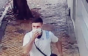 Alejandro David Rodríguez se cuelga el bolso de la víctima al hombro y escapa por la vereda de la calle Caballero.