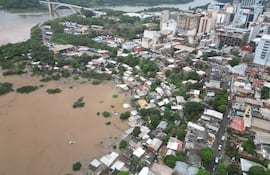 Vista aérea del barrio San Rafael con viviendas de techos coloridos y áreas inundadas de agua marrón.
