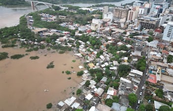 Vista aérea del barrio San Rafael con viviendas de techos coloridos y áreas inundadas de agua marrón.