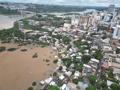 Vista aérea del barrio San Rafael con viviendas de techos coloridos y áreas inundadas de agua marrón.