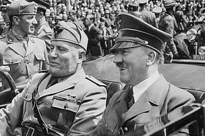 Esta foto de archivo de The National Archives, tomada en junio de 1940 en Múnich, Alemania, muestra a Adolf Hitler (der.) viajando en un automóvil con el dictador fascista italiano Benito Mussolini (izq.) durante la Segunda Guerra Mundial. Adolf Hitler muy probablemente padecía la afección genética Síndrome de Kallmann, que puede manifestarse con testículos no descendidos y micropene, según informaron investigadores y documentalistas el 13 de noviembre de 2025, tras realizar pruebas de ADN a la sangre del dictador nazi. La nueva investigación también desmiente la sugerencia de que Hitler tuviera ascendencia judía