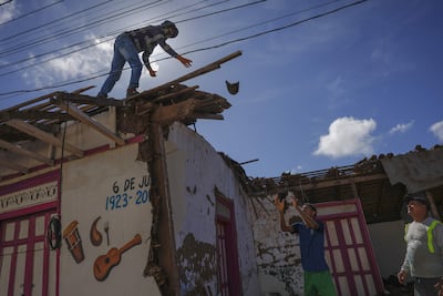 Personas trabajan en la demolición de una casa de Quincha afectada por el terremoto de magnitud 7,7.