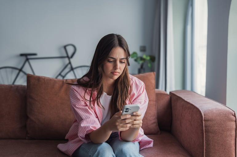 Mujer mira su celular.