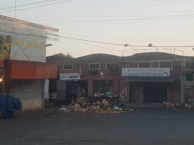 Un camión descargando basura en un contenedor rebasado, en el Mercado de Abasto.