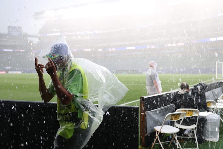 Un fotógrafo viste un impermeable mientras el partido de fútbol del Grupo I de la Copa del Mundo 2026 entre Francia e Irak es suspendido debido a las condiciones climáticas adversas en el Philadelphia Stadium en Filadelfia.