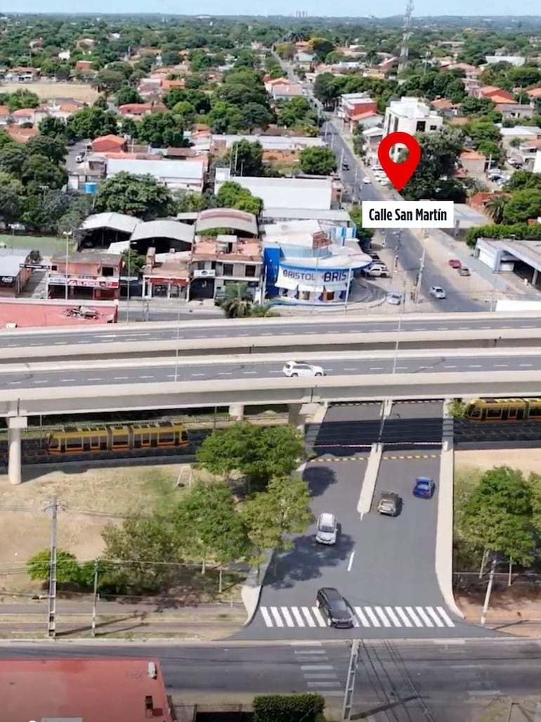 Vista aérea de la intersección con tráfico vehicular, destacando la estructura elevada en un entorno suburbano.