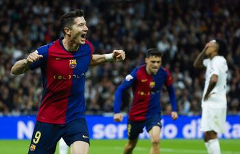 MADRID, 26/10/2024.- El delantero polaco del FC Barcelona Robert Lewandowski (i) celebra tras anotar un gol, durante el partido de la jornada 11 de LaLiga EA Sports entre el Real Madrid y el FC Barcelona, este sábado en el estadio Santiago Bernabéu, en Madrid. EFE/Juanjo Martín