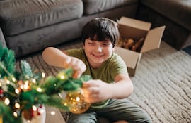 Niño ayuda con la decoración navideña.