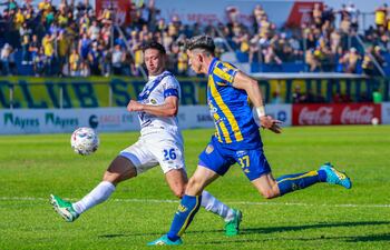 El extremo del Sportivo Luqueño, Lautaro Comas intenta escapar de la marca del zaguero y capitán de Sportivo Ameliano, Julio González Trinidad.