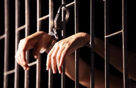 Imagen ilustrativa: una persona encarcelada y esposada.