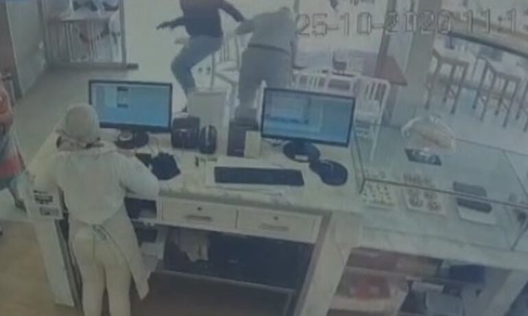 Con una pistola en la mano, el maleante arrstra a la víctima, un señor de 85 años para arrebatarle el reloj del brazo.