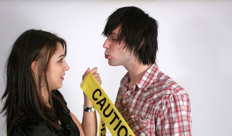 Un hombre intenta besar a una mujer que no quiere.