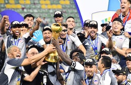 Los jugadores de Junior celebran con el trofeo de campeón del torneo Finalización 2025 después de superar 1-0 a Deportes Tolima en la revancha de la final en el estadio Manuel Murillo Toro, en Ibagué, Colombia.