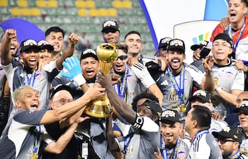 Los jugadores de Junior celebran con el trofeo de campeón del torneo Finalización 2025 después de superar 1-0 a Deportes Tolima en la revancha de la final en el estadio Manuel Murillo Toro, en Ibagué, Colombia.