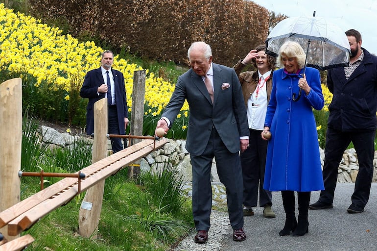 El rey Carlos III y la reina Camila observan un tramo de una nueva pista de canicas creada para los visitantes a lo largo de más de 100 metros de pista de madera hecha a mano, durante un evento para conmemorar el 25 aniversario del Proyecto Edén en Bodelva, Cornualles. (Toby Shepheard / POOL / AFP)