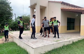 Néstor Javier Benítez Struway (pantalón negro) y Eugenio Daniel Martínez (short negro), supuestos miembros de la banda Campanas de Belén, en la iglesia San Juan Bautista de Caraguatay, donde fueron capturados por la Policía.