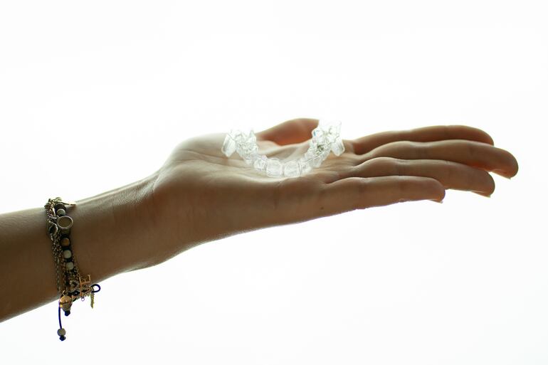 Paciente con férula dental en la palma de su mano. Foto: Dental Studio.
