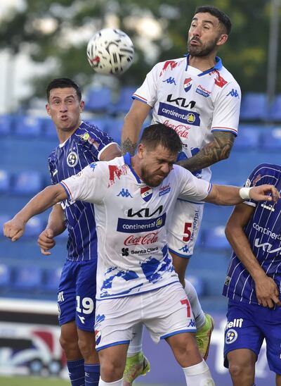 El defensor de Nacional Sergio Ojeda se eleva para intentar conectar de cabeza para rechazar. Su compañero Edgardo Orzusa queda por debajo y atrás se le observa al solense Ronald Roa.