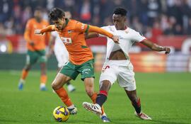SEVILLA, 11/01/2025.- El centrocampista belga del Sevilla Albert-Mboyo (d) lucha con el portugués Andre Almeida, del Valencia, durante el partido de la jornada 19 de LaLiga que Sevilla FC y Valencia CF disputan este sábado en el Ramón Sánchez-Pizjuán, en Sevilla. EFE/Julio Muñoz