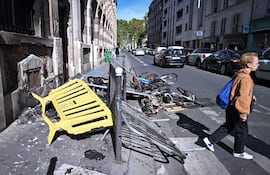 Un peatón pasa junto a los daños causados tras los enfrentamientos entre la policía antidisturbios y manifestantes durante una protesta de estudiantes de secundaria contra las condiciones educativas en París, Francia, el 2 de octubre de 2026.
