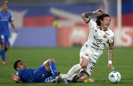 El mediocampista trasandino de la Universidad de Chile Israel Poblete (30 años) se desliza por el césped para impedir el avance del atacante y capitán aurinegro Fernando “Queso” Fernández (33).