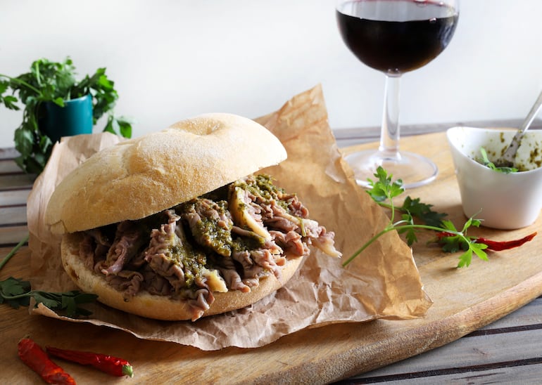 Sándwich Lampredotto, un sándwich florentino clásico cubierto con una salsa picante o una salsa verde. Comida tradicional callejera en Florencia, Italia.