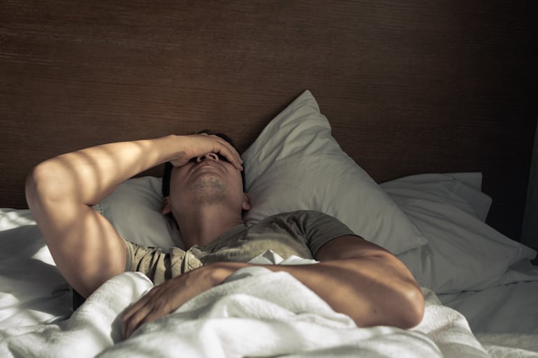 Hombre cansado en la cama.
