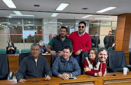 Jesus Lara con cabello canoso y suéter negro, Rossana Rolon en suéter rojo, Juan José Arnold y Camilo Pérez en ambiente de reunión.