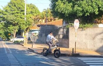Con corbata y en bicicleta eléctrica este oficinista recorre la bicisenda sobre la calle San Alfonso, en el barrio Mburicaó de Asunción.