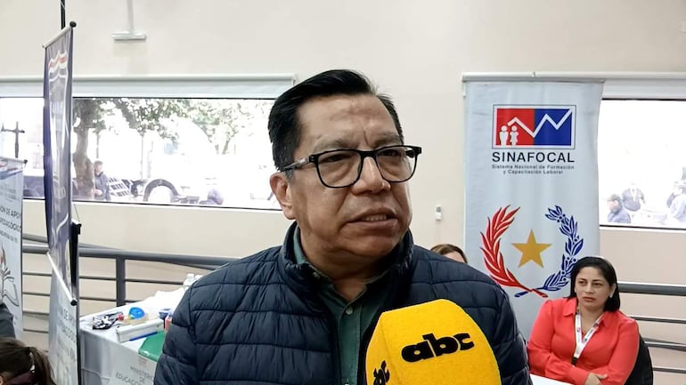 Tadeo Rojas en abrigo oscuro habla con micrófono, mientras una mujer lo escucha atentamente en un entorno profesional.
