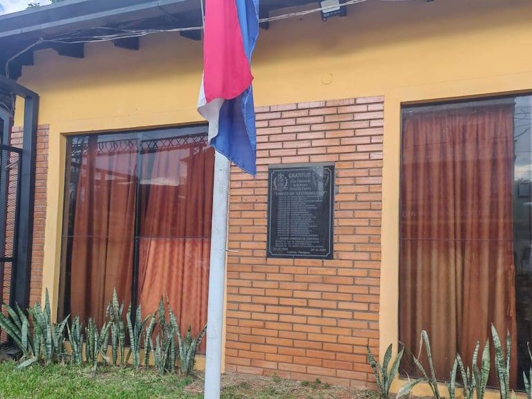 Fachada del cuartel de la 8va Compañía con bandera paraguaya y placa de agradecimiento en un ambiente de solemnidad.