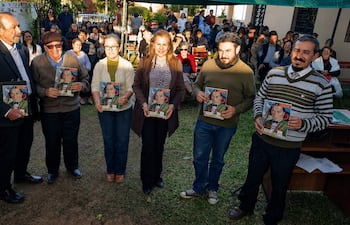 Gil Alegre en traje, Rafael Montiel y cuatro miembros del CEC sosteniendo documentos, rodeados de un público en un ambiente al aire libre.