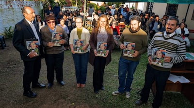 Gil Alegre en traje, Rafael Montiel y cuatro miembros del CEC sosteniendo documentos, rodeados de un público en un ambiente al aire libre.