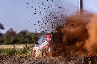 Automóvil de rally levantando polvo en un tramo off-road, sin personas visibles en la escena.