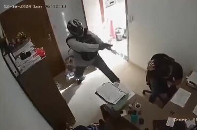 Uno de los motochorros ingresa a la oficina administrativa para robar la recaudación del fin de semana.