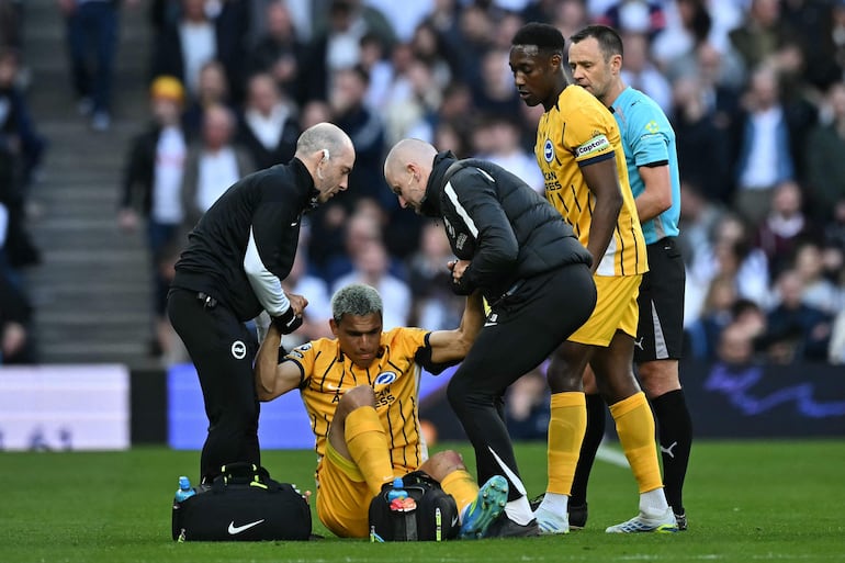 El paraguayo Diego Gómez, futbolista de Brighton, es asistido luego de sufrir una lesión en la rodilla izquierda al disputar un balón aéreo durante el partido frente a Tottenham por la fecha 33 de la Premier League en el estadio Tottenham Hotspur, en Londres, Inglaterra.