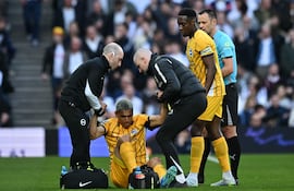 El paraguayo Diego Gómez, futbolista de Brighton, es asistido luego de sufrir una lesión en la rodilla izquierda al disputar un balón aéreo durante el partido frente a Tottenham por la fecha 33 de la Premier League en el estadio Tottenham Hotspur, en Londres, Inglaterra.